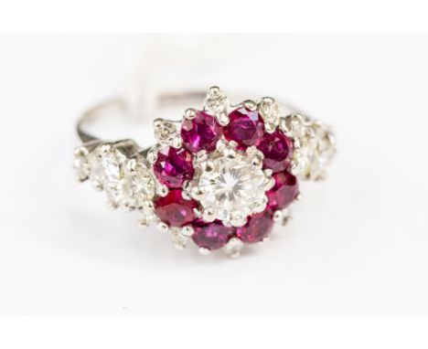 A diamond and ruby cluster ring, the central round brilliant cut diamond approx. 0.75 carat, a surround of rubies with diamon