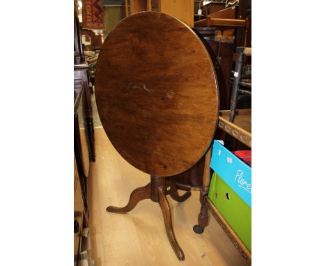 A George III oak tilt-top tripod table, standing on cabriole legs