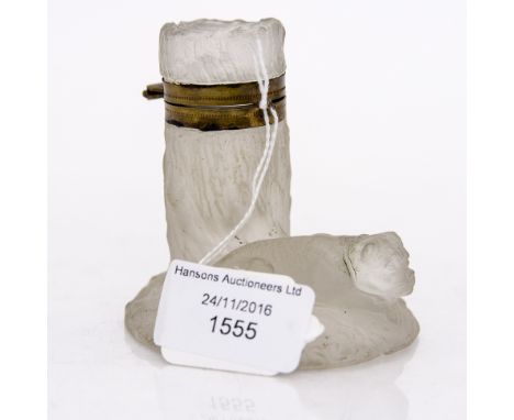 An Art Nouveau pressed glass inkwell, frosted, modelled as a dog resting before a tree stump, with gilt metal mounts, 8cm hig