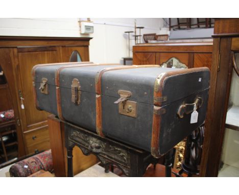 An early 20th Century steamer trunk with batoning re-enforcement lined with decorated paper, leather handles 