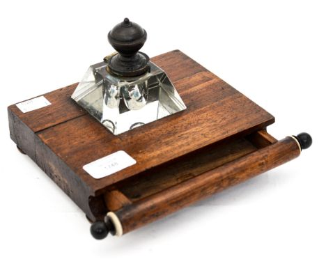 A Victorian glass inkwell with mirrored base magnifying a Christmas greeting, mounted on a mahogany stand fitted with a slim 