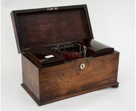 An early 19th Century rosewood tea caddy of rectangular form, with wooden insert caddies and glass mixing bowl, two feet deta