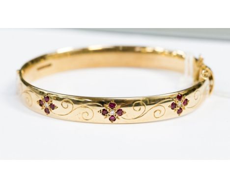 A 9ct gold hinged bangle set with diamond and ruby floral cluster 