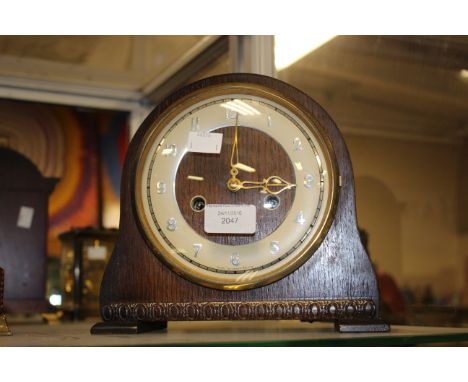 An early 20th Century Smiths Enfield oak cased eight day mantle clock, cream chapter dial with Arabic numerals and two winder