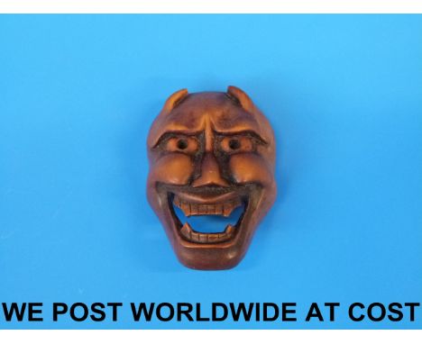 A Japanese boxwood mask netsuke of a demon 