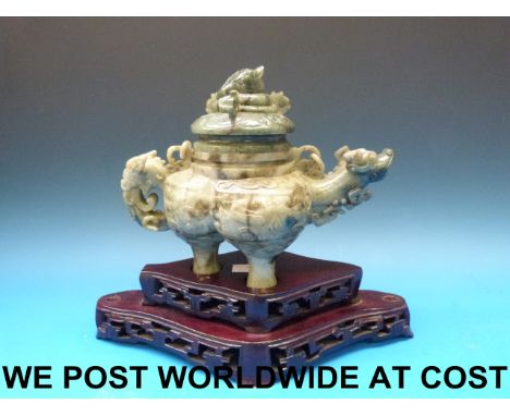 A Chinese jadeite large tripod teapot and cover with coiled dragon finial, the stone with some dark green splashes, all on fi
