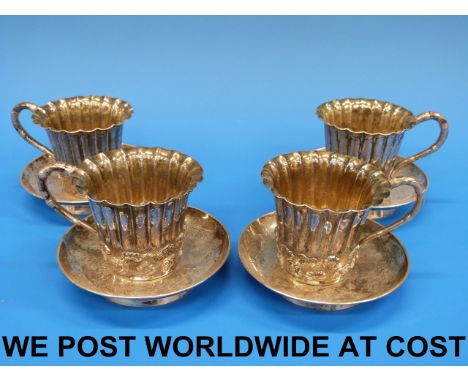 Four Chinese silver cups and saucers with prunus decoration (maker KH). Each is 7cm high including saucer. Saucer 9.7cm diame