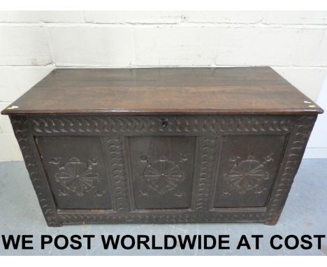 A 17thC /18thC peg jointed oak coffer having three panel carved front and S scallop decoration to frame, opening to reveal ca