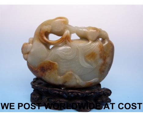 A fine 18thC Chinese pale celadon and russet jade duck carved in the archaistic style, the duck on a large lotus leaf graspin