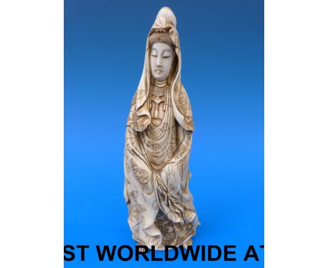 A Chinese ivory figure of Guanyin with incised floral decoration to robe (19.5cm tall)