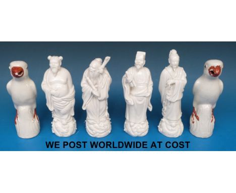 Four Chinese blanc de chine figures of immortals together with a pair of ceramic ceramic parrots