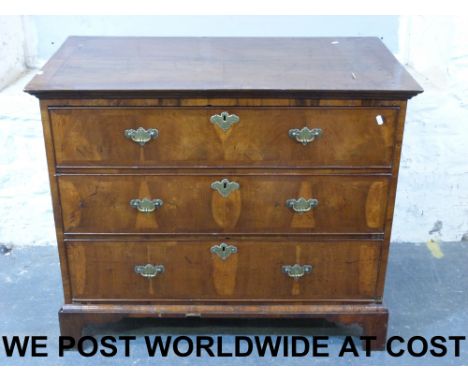 A Georgian walnut straight chest of drawers, the top with fine feather banding and cross banded border, the three long drawer