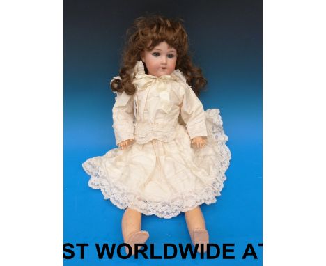 An Armand Marseille bisque headed doll with open mouth, weighted blue eyes, brown hair and jointed limbs. Marked to the back 