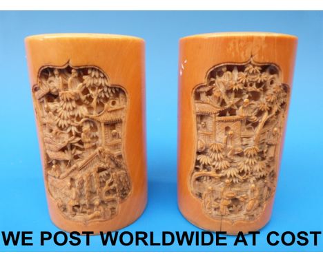 A pair of Chinese Canton ivory vases of cylindrical form with scenes of figures, trees and pagodas (8.5cm tall)