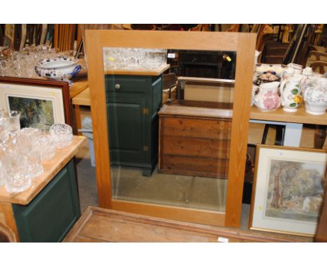 A light oak framed and bevel edged wall mirror