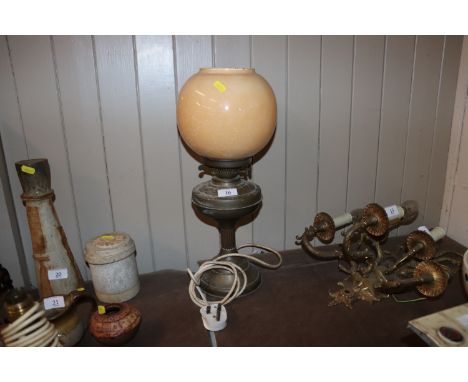 A brass oil lamp and glass shade converted to electricity 
