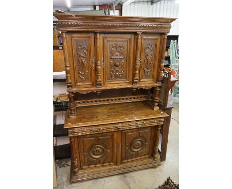 19th century Carved Oak Gothic Cabinet, the upper structure with three carved panel doors, all opening to shelves raised on t