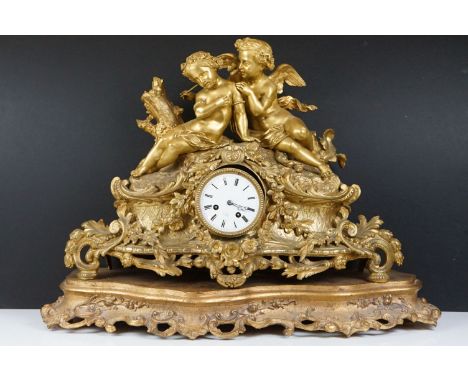 19th Century gilt metal mantle clock having a central white enamelled face with roman numerals to the chapter ring, set benea