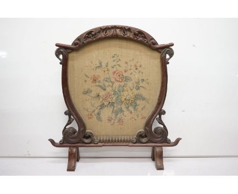 Victorian Firescreen, the frame with foliate carving and the centre with hand painted fabric panel of flowers, 84cm wide x 90