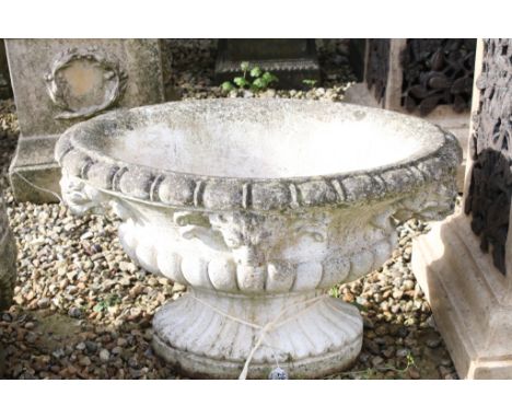 Reconstituted stone garden planter of oval form, with relief lion masks, raised on a fluted oval foot. (Measures approx 69cm 