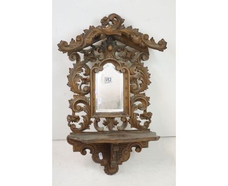 Black Forest Walnut Hanging Hall Mirror and folding Shelf, carved with foliate scrolls, 59cm high x 39cm wide 