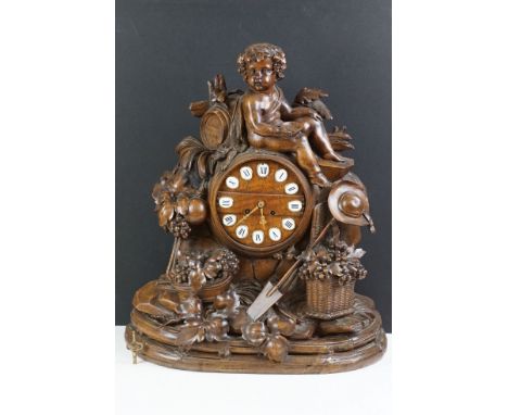 19th Century Black Forest carved walnut key-wind chiming mantel clock, the circular dial of barrel form, with enamelled Roman