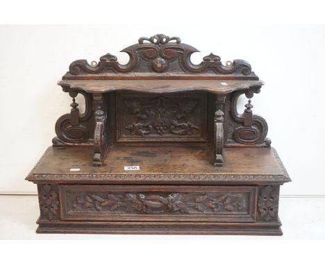 19th century Carved Oak Hanging Cabinet, the shaped back with a shelf over a single drawer, with foliate carving, possibly Bl