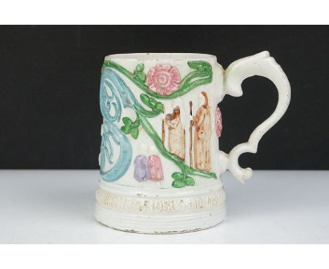 19th Century Victorian Compton Pottery mug decorated in relief with figures and foliate patterns, with an inscription around 