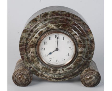 An serpentine mantle clock, with an 8cm white enamel dial and eight day French movement, height 20.5cm, width 22cm. 