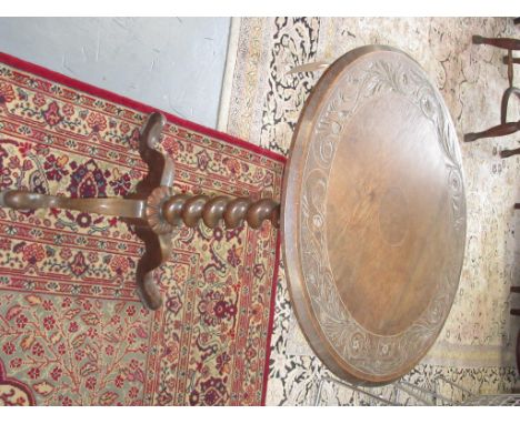 A 19th century tripod table, with a circular carved oak top on a walnut spiral twist stem and cabriole supports, height 73cm 