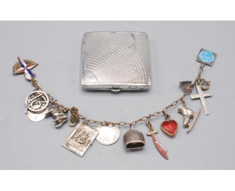 A silver engine turned small compact marked 'Vogue' together with a bracelet strung with silver and other charms.