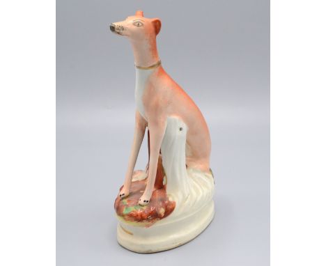 A Staffordshire seated model of a coursing greyhound and hare, height 21.5cm.   Condition report:  Slight loss of enamel to n