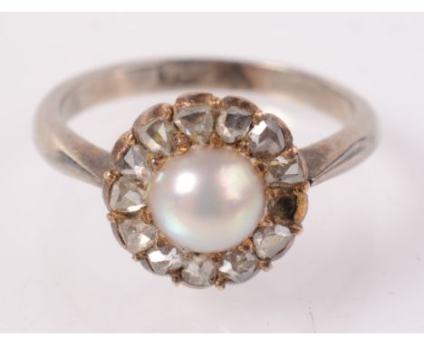 A 9ct white gold ring with a pearl and diamond cluster.
