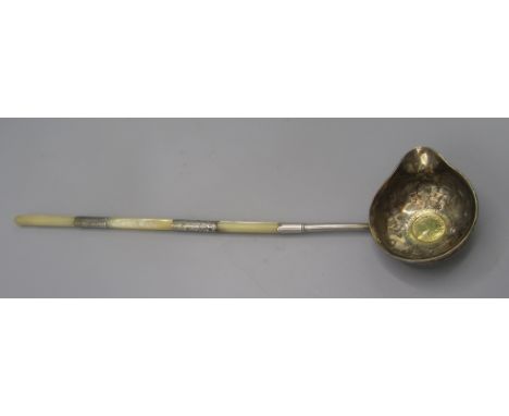 An 18th century silver punch ladle, the bowl set with a Queen Anne sixpence, dated 1711, the mother of pearl handle with chas