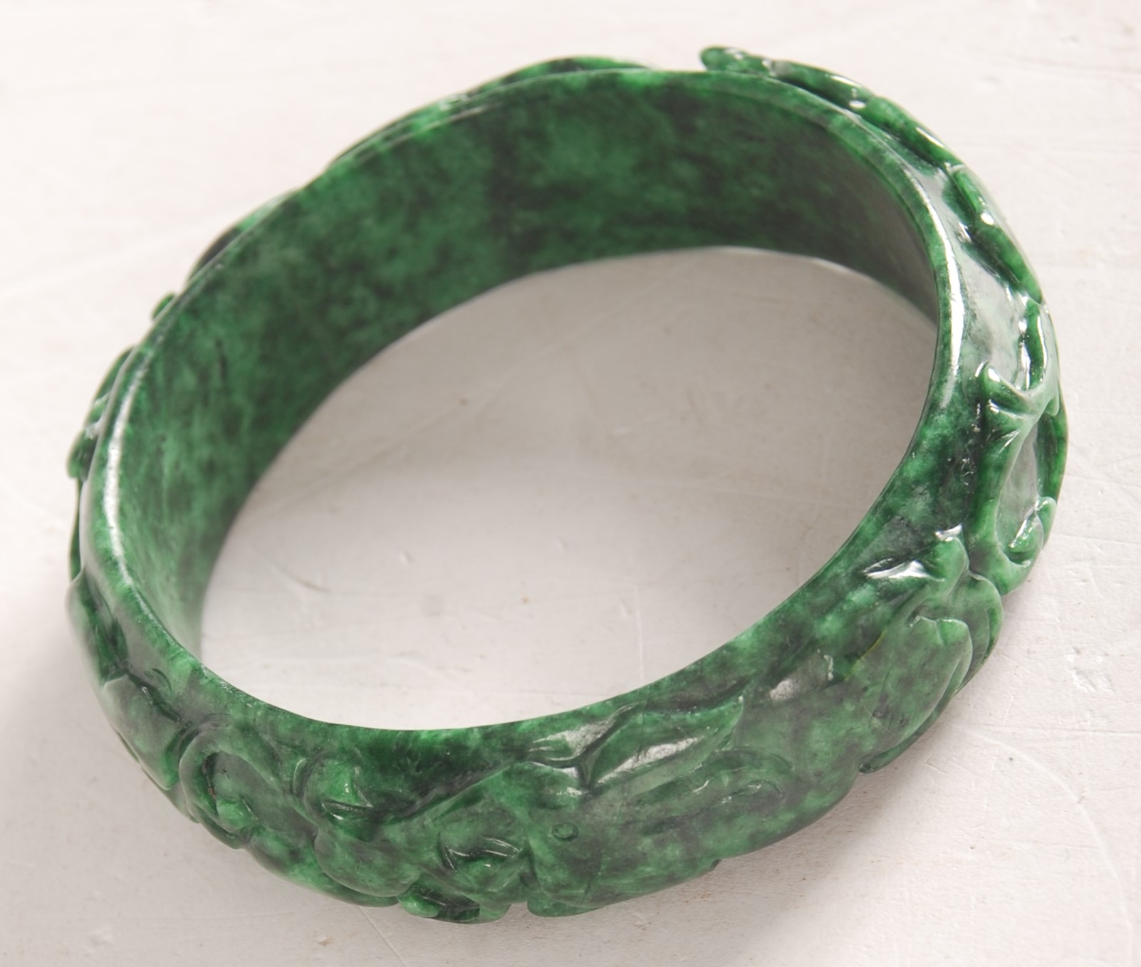 A Chinese carved spinach jade bangle.