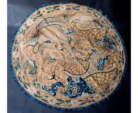 A Chinese Beijing silk roundel for a robe or wall panel, finely embroidered in gold, blue and white silks with ling chin fung