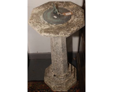 A metal sundial on a composition octagonal plinth base, height 83cm, width 38.5cm. 