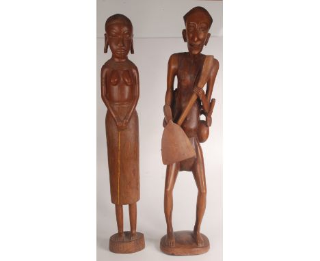 Two large East African carved figures of a farmer holding an axe, height 97cm and his wife.Provenance: Our client bought thes