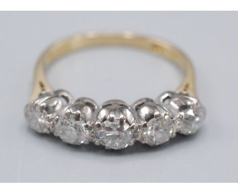 An 18ct gold ring set with a row of five diamonds.