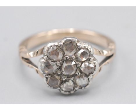 A gold ring, cluster set with rose cut diamonds.