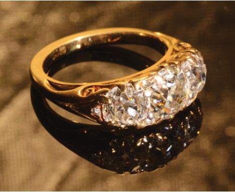 A good 18ct. gold Victorian style ring set with a central diamond of approximately 1ct. spread flanked by diamonds, each of a