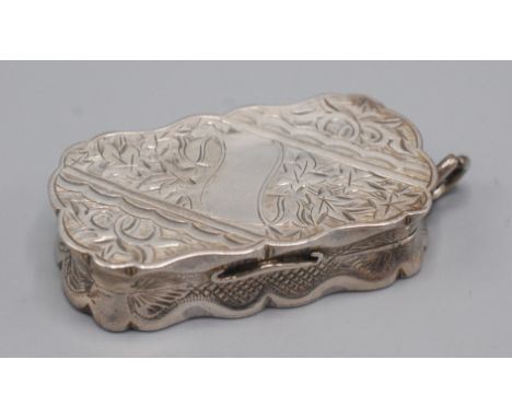 A Victorian oval silver vinaigrette by Hilliard & Thomason, Birmingham 1888, with engraved decoration and a suspension ring. 