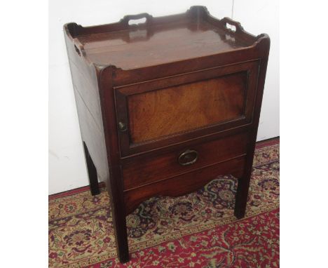 A George III mahogany tray top commode, with three pierced handles above a single panelled door and a short drawer, on square