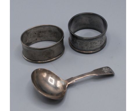 A George IV fiddle pattern caddy spoon and two silver napkin rings.
