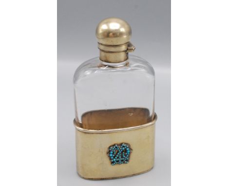 A glass spirit flask by Jenner and Knewstub with silver gilt bayonet top the silver gilt cup base with a turquoise set monogr