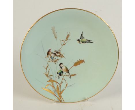 A Royal Worcester porcelain cabinet plate painted with blue tits in flight and perched on gilt decorated rushes, all on a tur