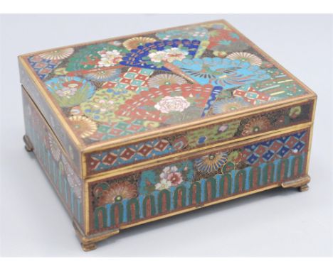 A Japanese cloisonne cigarette box, decorated an exotic bird and foliage, on brass bracket feet, the underside decorated with