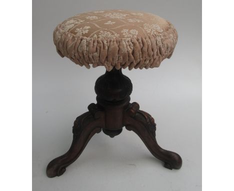 A Victorian music stool with carved tripod base.