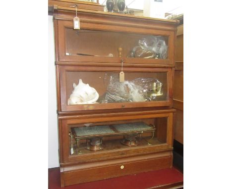 An oak Globe Wernicke style sectional bookcase, with three glazed doors and a plinth base, with plaque inscribed 'SU-TALL & C