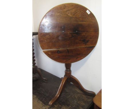 An oak tripod table, 19th century, the circular top on a turned baluster stem and downswept supports.